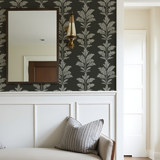 Decorative wall with mirror and leaf-patterned wallpaper above a white bed.